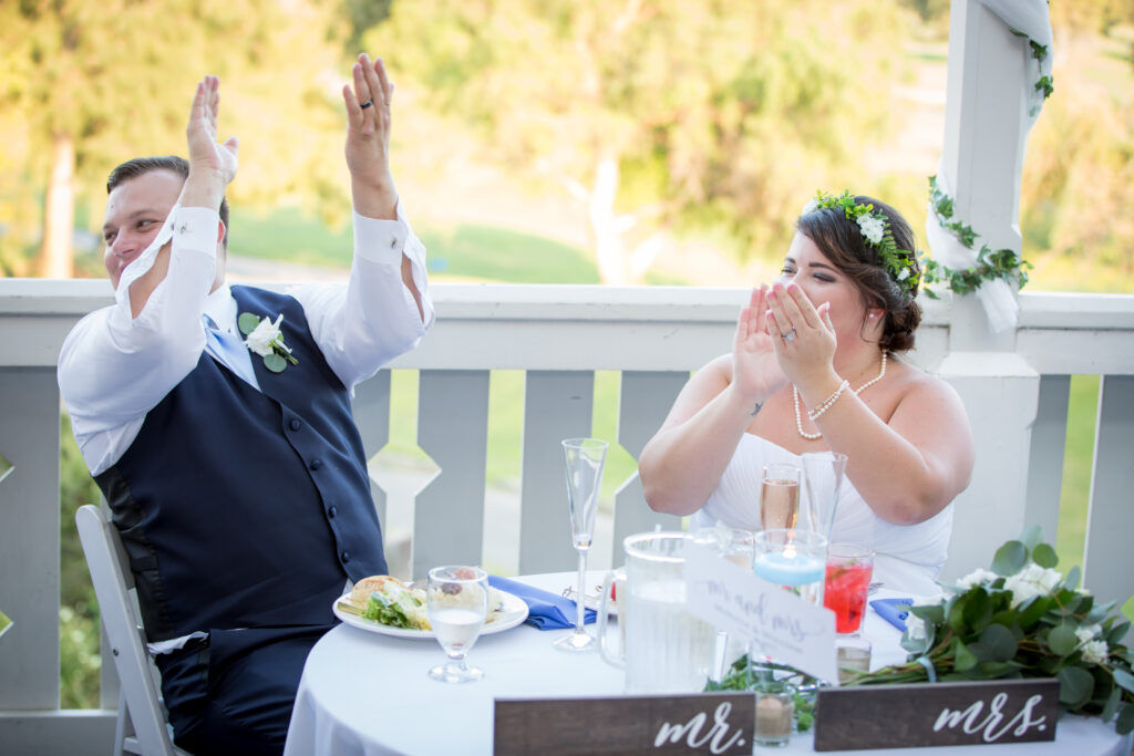 Bride and Groom clapping at dinner table