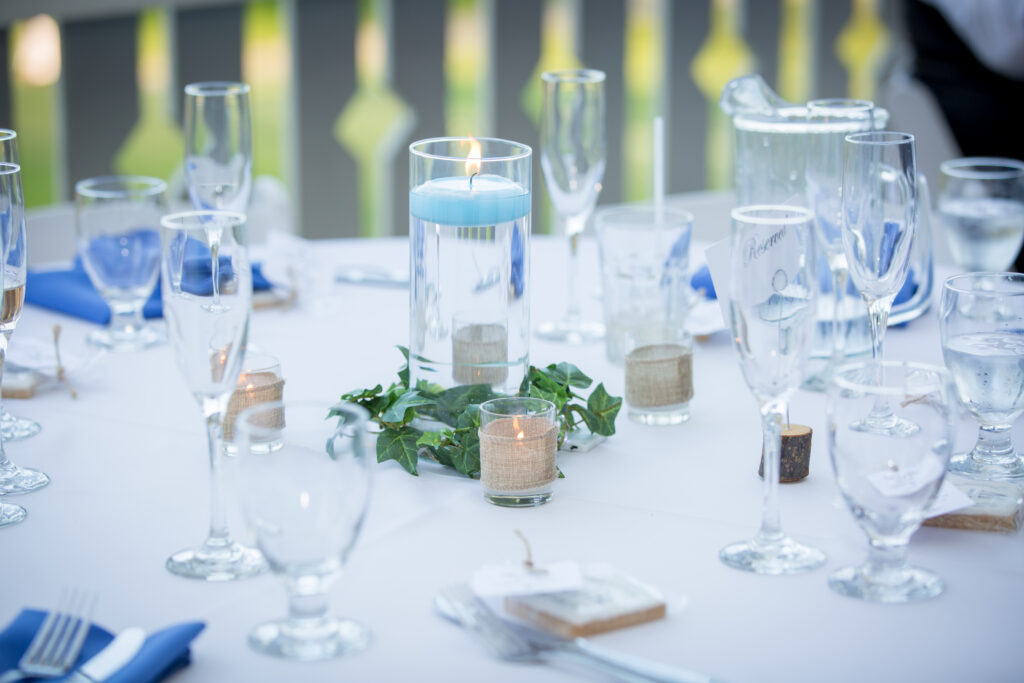 Table set up with blue napkins, glasswear and lit candles